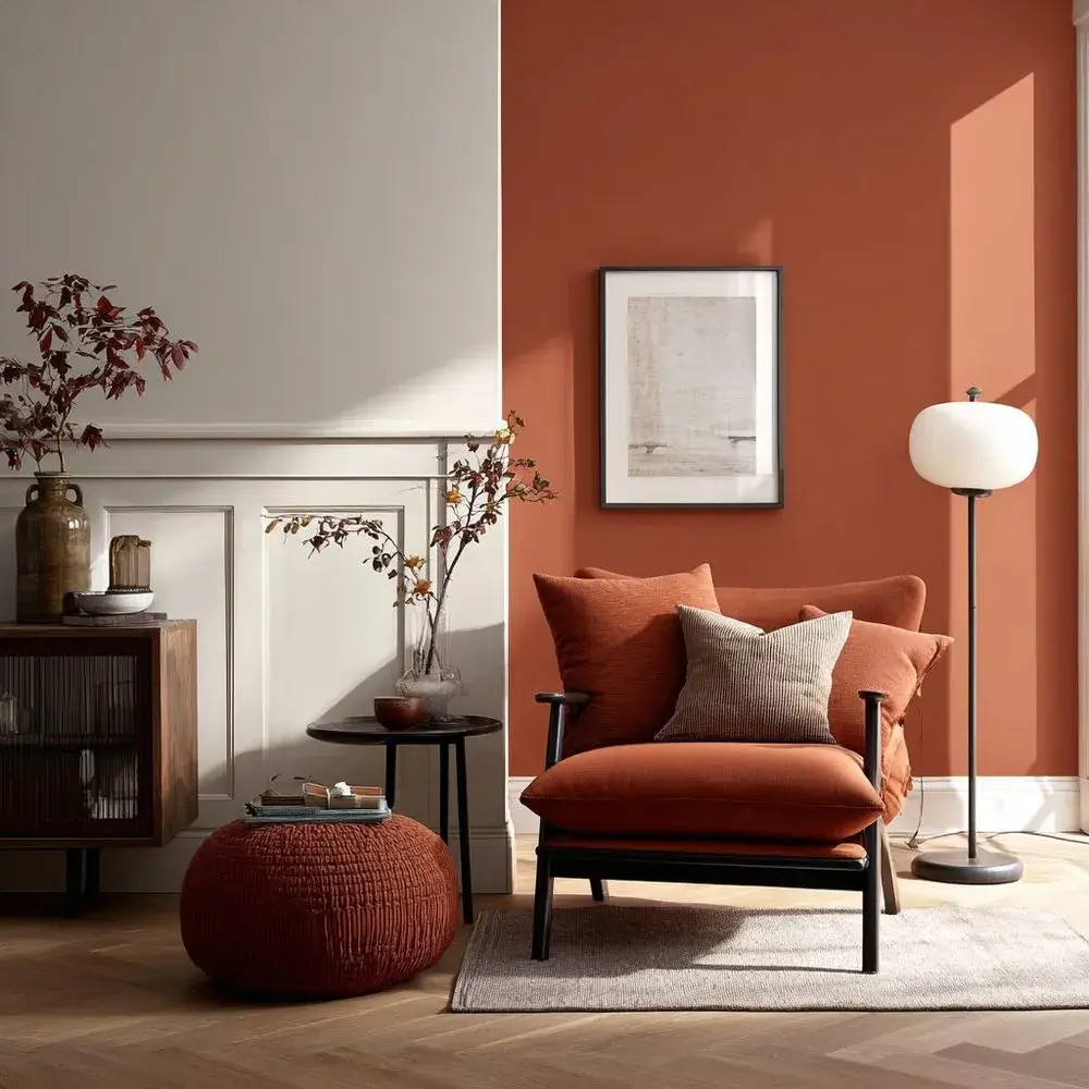 A living room with a bold terracotta accent wall and warm neutral surroundings